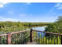 Relaxing view of the lush green landscape from the wooden balcony with black iron railings at 1401 S Palmetto Ave # 614, Daytona Beach, FL 32114