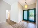 Bright entryway with dark green double doors, wood-look floors, and a mirrored wall at 1412 Oak Forest Dr, Ormond Beach, FL 32174