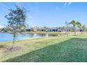 View of a lake and other houses from a backyard with grass at 1627 Delphi Way, New Smyrna Beach, FL 32168