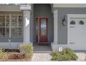 Red front door entrance with white columns and brick walkway at 204 Wellington Woods Ave, Deland, FL 32724