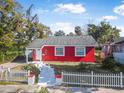 Red brick house with white picket fence, walkway, and landscaping at 229 S Adams St, Daytona Beach, FL 32114