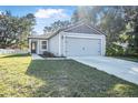 Newly built gray house with a gray garage door and green lawn at 2373 Weldon Ct, Deltona, FL 32738