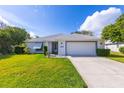 Single-story home with white exterior, attached garage, and well-manicured lawn at 2758 Turnbull Cove Dr, New Smyrna Beach, FL 32168