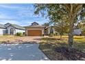 House exterior showcasing a wooden garage door and brick driveway at 3169 Connemara Dr, Ormond Beach, FL 32174
