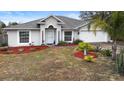 Single story home with gray siding, red mulch, and a two-car garage at 337 Orange Ave, Orange City, FL 32763