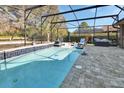 Relaxing screened-in pool area, featuring tiled pool and stone patio, perfect for outdoor living at 428 Hightower Dr, Debary, FL 32713