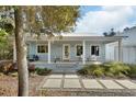 Charming front porch with seating, a metal roof, stepping stones, and tasteful landscaping create inviting curb appeal at 4525 Owls Nest Ct, De Leon Springs, FL 32130