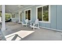 Inviting covered porch featuring comfortable seating, ceiling fans, and ample space for relaxation with views of the landscape at 4525 Owls Nest Ct, De Leon Springs, FL 32130