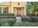 Front entry with a brown door and neatly trimmed shrubs at 555 Morgan Wood Dr, Deland, FL 32724