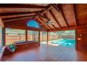 Spacious sunroom featuring a tongue-and-groove ceiling, tile floor, large windows, and views of the screened-in pool at 709 Lone Oak Dr, Port Orange, FL 32127