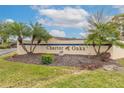Community entrance sign of Charter Oaks, featuring palm trees and landscaping at 1260 Charter Oaks Cir, Daytona Beach, FL 32117