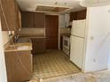 Dated kitchen with wood cabinets and vinyl flooring at 1525 S Hayden Rd, Deland, FL 32724