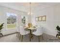 Bright dining room featuring a modern chandelier, white chairs, and sunlight from the window at 1870 S Lehigh Dr, Deltona, FL 32738