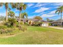 Beautiful home exterior with palm trees and flowerbeds in a vibrant green lawn at 1930 Seclusion Dr, Port Orange, FL 32128