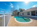 Kidney-shaped pool with a patio and white fence overlooking a lake at 2370 Alton Rd, Deltona, FL 32738