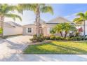 Well-maintained house with palm trees and a brick driveway at 238 Venetian Palms Blvd, New Smyrna Beach, FL 32168