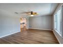 Open-concept living room featuring wood-look floors, ceiling fan, and archway to the kitchen at 4365 S Peninsula Dr, Ponce Inlet, FL 32127