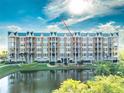 Beautiful condo building overlooking a serene pond, featuring a charming coastal aesthetic and lush greenery at 4672 Riverwalk Village # 8406, Ponce Inlet, FL 32127