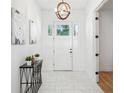 Bright foyer featuring tiled floors, modern lighting fixture, and stylish decor at 475 W Main St, Lake Helen, FL 32744