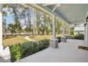 Inviting front porch with stone columns, ceiling fans, and a view of the spacious front yard at 475 W Main St, Lake Helen, FL 32744