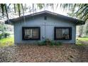 Rear view of house showing two windows and landscaping at 5450 Park Ave, De Leon Springs, FL 32130