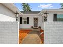 Inviting front entrance with brick columns, manicured planters, and a stylish security door at 728 Vicksburg St, Deltona, FL 32725