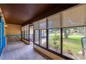 Inviting sunroom with large windows offering ample natural light and serene outdoor views with wood look flooring at 949 Tall Pine Dr, Port Orange, FL 32127