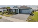 Inviting single-story home with paved driveway, blue siding, and lush green lawn, offering curb appeal at 105 Cerise Ct, Daytona Beach, FL 32124