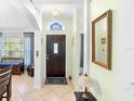 Bright entryway with a dark wood front door and decorative mirror at 1081 Treadway Dr, Deltona, FL 32738