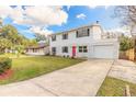 Two-story home with bright red front door and a long driveway, showcasing its curb appeal at 1195 10Th St, Daytona Beach, FL 32117