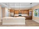 Bright kitchen with stainless steel appliances, center island, and decorative pendant lighting at 177 Rosedale Dr, Deltona, FL 32738