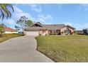 Lovely brick home featuring a spacious front yard, two-car garage, and picturesque landscaping at 2075 Little Farms Ct, Deltona, FL 32738