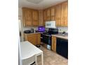 Charming kitchen featuring oak cabinets, a black dishwasher, and stainless steel appliances at 2201 S Peninsula Dr, Daytona Beach, FL 32118