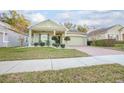 House exterior featuring a two-car garage and well-manicured lawn at 242 W Fiesta Key Loop, Deland, FL 32720