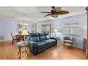 Open-concept living room with hardwood floors, blue sofa, and plenty of natural light at 2610 Hialeah Ave, The Villages, FL 32162