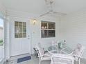 A screened in patio with a table, chairs, an overhead light, and a ceiling fan at 2610 Hialeah Ave, The Villages, FL 32162