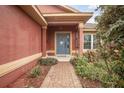 Inviting front entrance with landscaped garden leading up to a blue front door at 35909 Joewood Ave, Leesburg, FL 34788