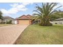 Charming home with a lush lawn, brick driveway, and eye-catching tree at 35909 Joewood Ave, Leesburg, FL 34788