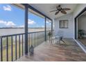 Screened porch featuring wood-look tile and views of the lake beyond the metal railing at 510 Sandy Bluff Trl, Deland, FL 32724