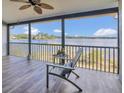 Screened porch featuring wood-look tile and views of the lake beyond the metal railing at 510 Sandy Bluff Trl, Deland, FL 32724