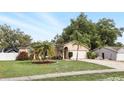 Lovely single-story home featuring a well-manicured lawn, mature landscaping, and an attached two-car garage at 583 Wilburton Dr, Deltona, FL 32738