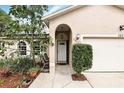 Close-up of a home's front entrance featuring a covered porch with an arched entry and well-maintained landscaping at 583 Wilburton Dr, Deltona, FL 32738