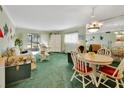Cozy living room with an adjacent dining area, green carpet, and an abundance of natural light at 600 N Boundary Ave # 114B, Deland, FL 32720