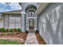 Close-up of the front entrance, featuring a stylish door and well-manicured landscaping at 6150 Half Moon Dr, Port Orange, FL 32127