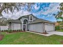 Charming gray two-story home showcasing a well-maintained lawn and inviting curb appeal at 6150 Half Moon Dr, Port Orange, FL 32127