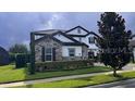 Charming two-story home with a stone-accented facade, manicured lawn, and paved driveway at 6301 Swanson St, Windermere, FL 34786