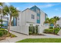 Modern condo complex exterior with white fence, palm trees, and blue accents at 7740 Sandy Ridge Dr # 206, Kissimmee, FL 34747