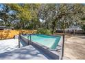 Backyard pool with a concrete deck and privacy fence, surrounded by mature landscaping at 829 Madison Ave, Daytona Beach, FL 32114