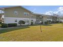 Scenic view of condo building with lush green lawn and mature trees under a bright blue sky at 840 Center Ave # 90, Daytona Beach, FL 32117