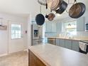 Functional kitchen featuring an island, stainless steel appliances, and light blue cabinets at 907 Rose Ln, The Villages, FL 32159